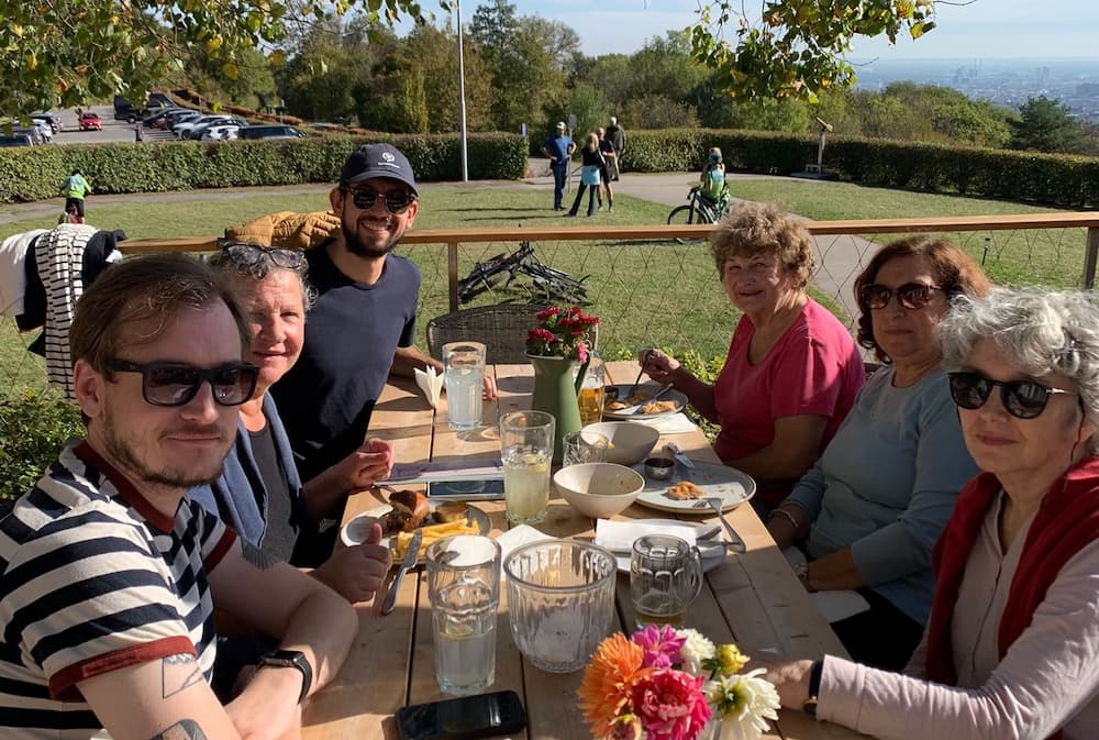 les membres de l'association déjeunent en terrasse d'un restaurant des collines viennoises sous un beau soleil de printemps